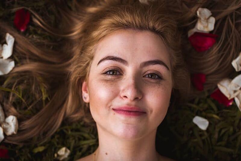 A person lying on the ground with flowers
AI-generated content may be incorrect.
