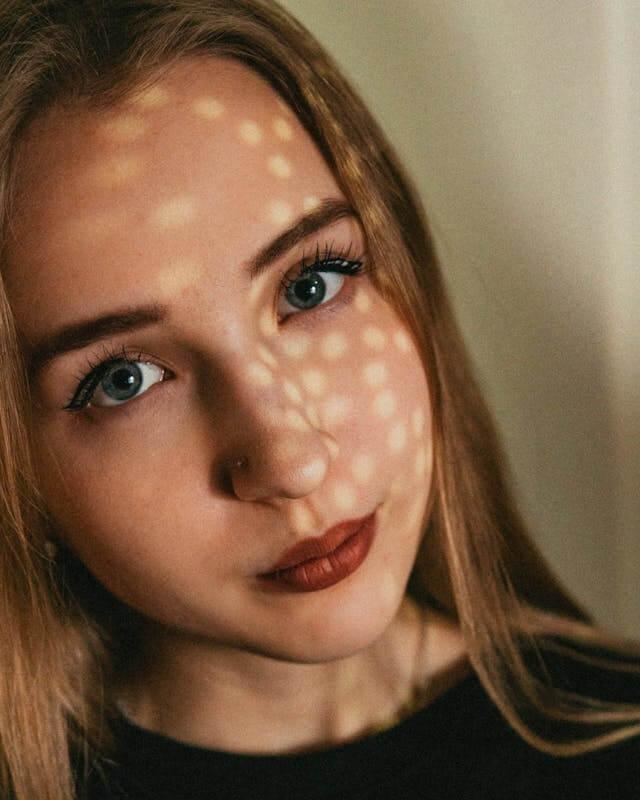 A person with a light on her face
AI-generated content may be incorrect.